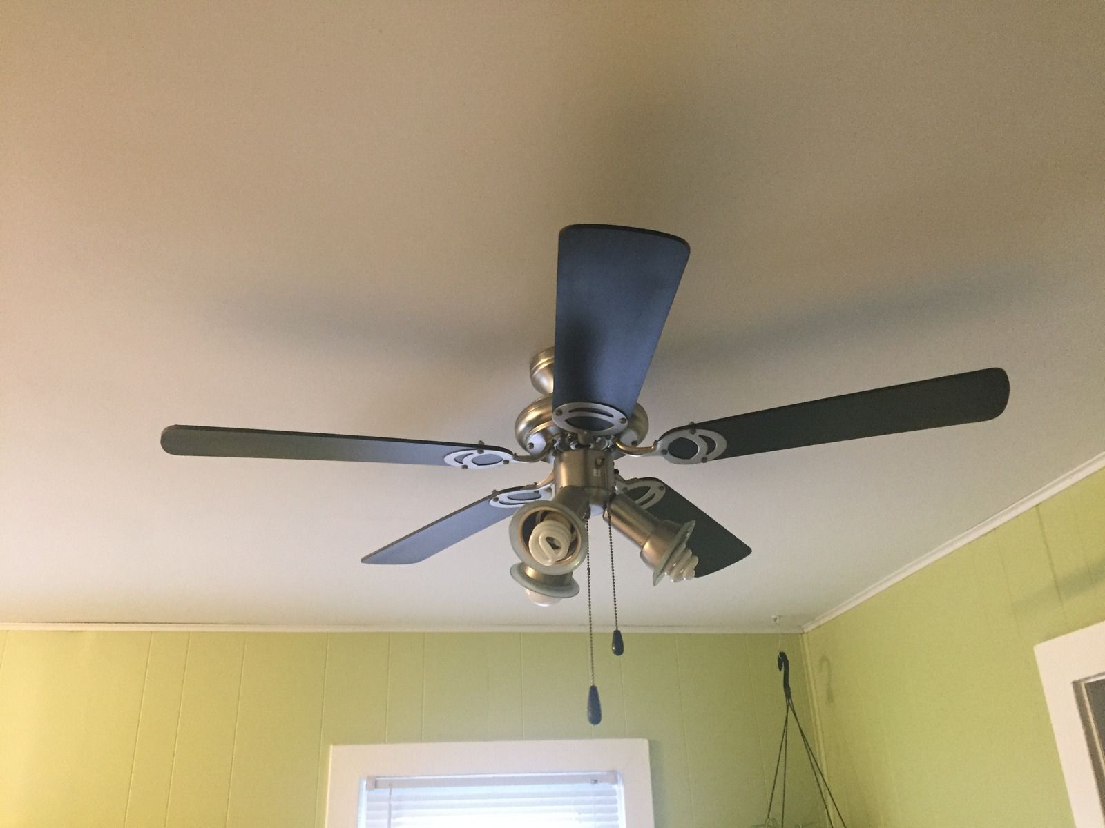 A ceiling fan is hanging from the ceiling of a room.