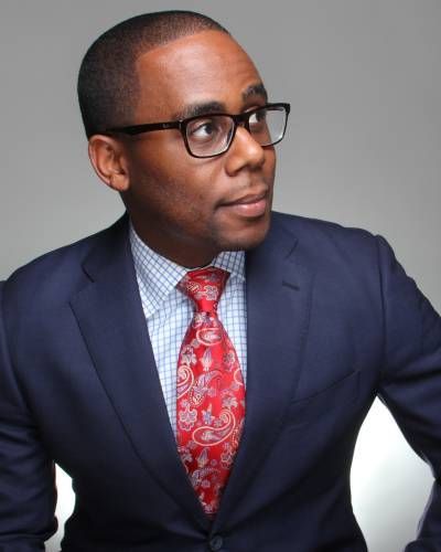 A man in a suit and tie is wearing glasses