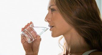 Woman drinking a glass of water — Saxton Well Service in Tinonesta, PA