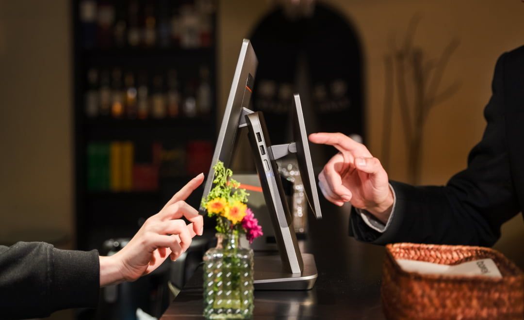 Smiling barista in a cafe looking at receipt while entering order into  Front Station restaurant POS system.