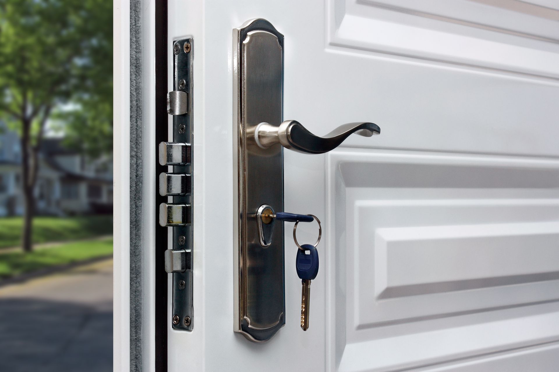 Open White Door With Chrome Handle and Multiple Locks, Key in the Lock — Cairns Locksmiths in Gordonvale, QLD