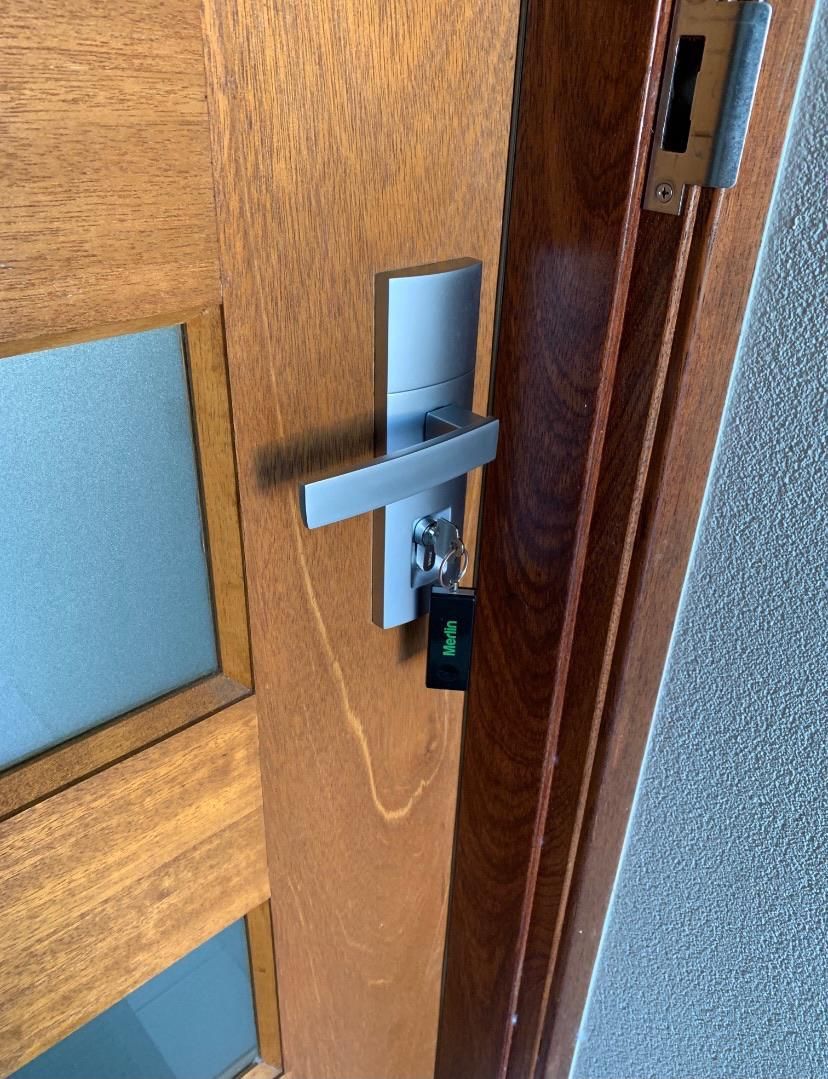 Wooden door with silver handle and key card — Cairns Locksmiths in Woree, QLD