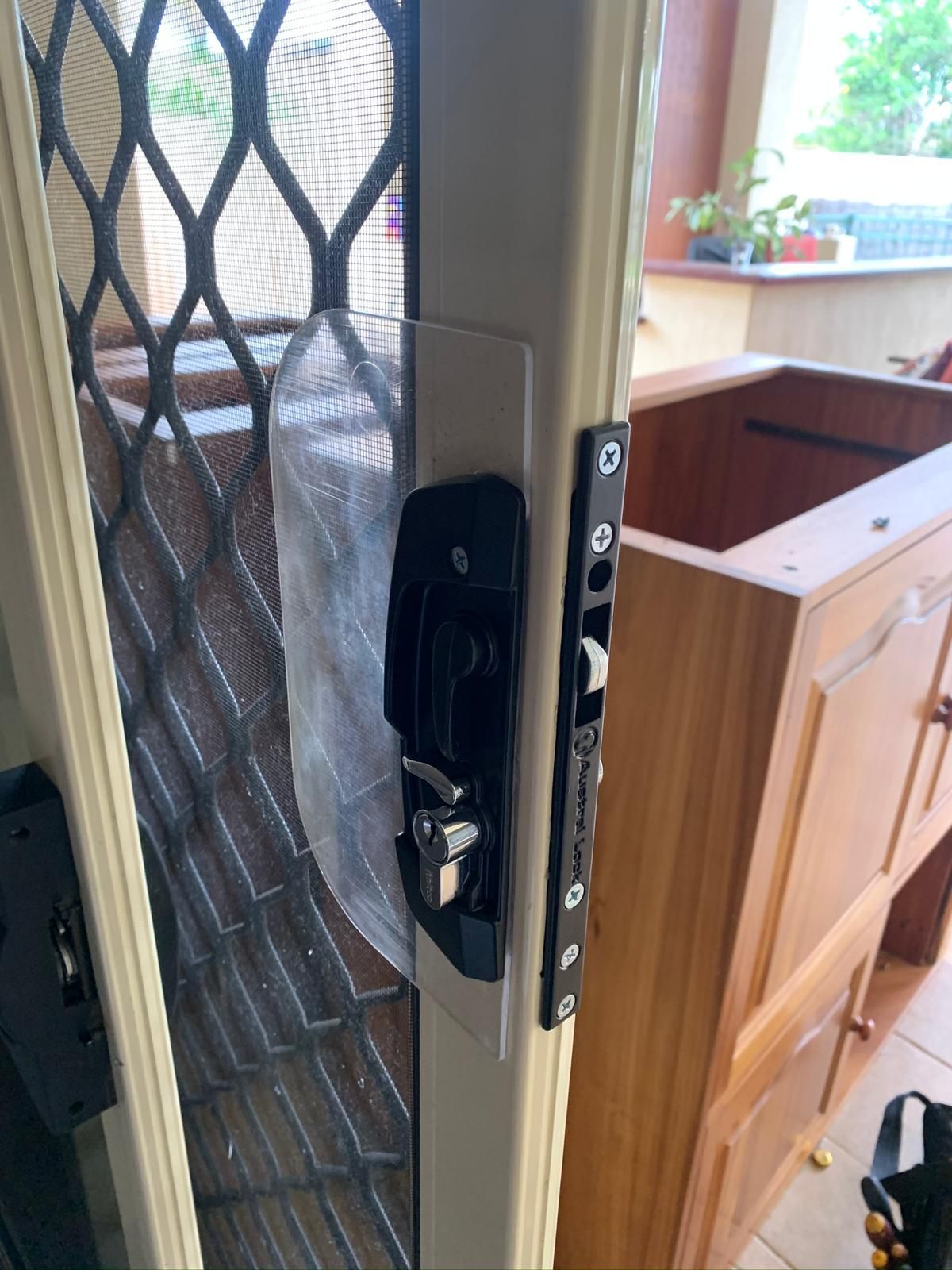 Black door lock on a screen door with a black frame— Cairns Locksmiths in Edmonton, QLD