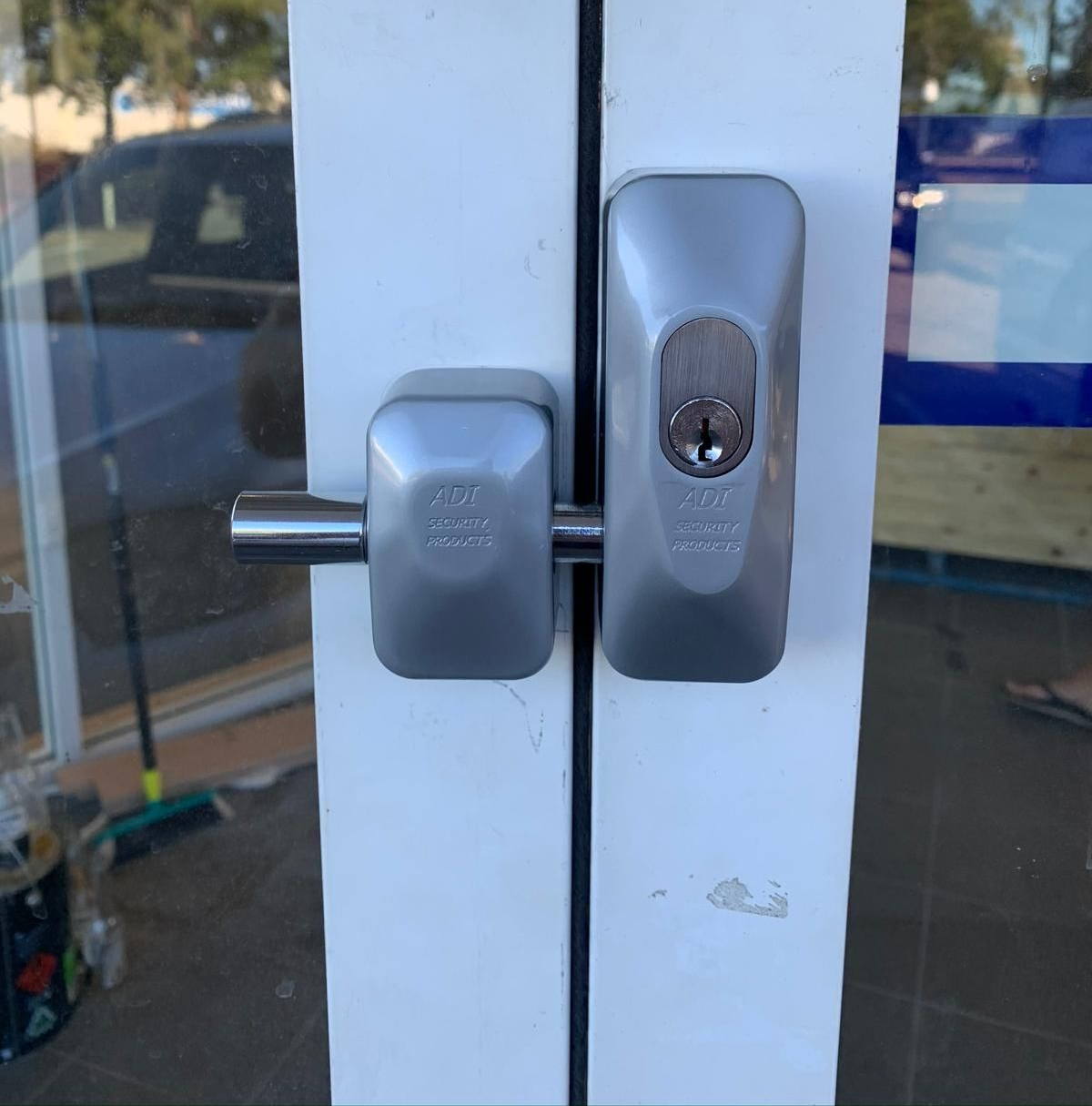 Person Using a Yellow Drill to Install a Door Lock on a White Door — Cairns Locksmiths in Woree, QLD
