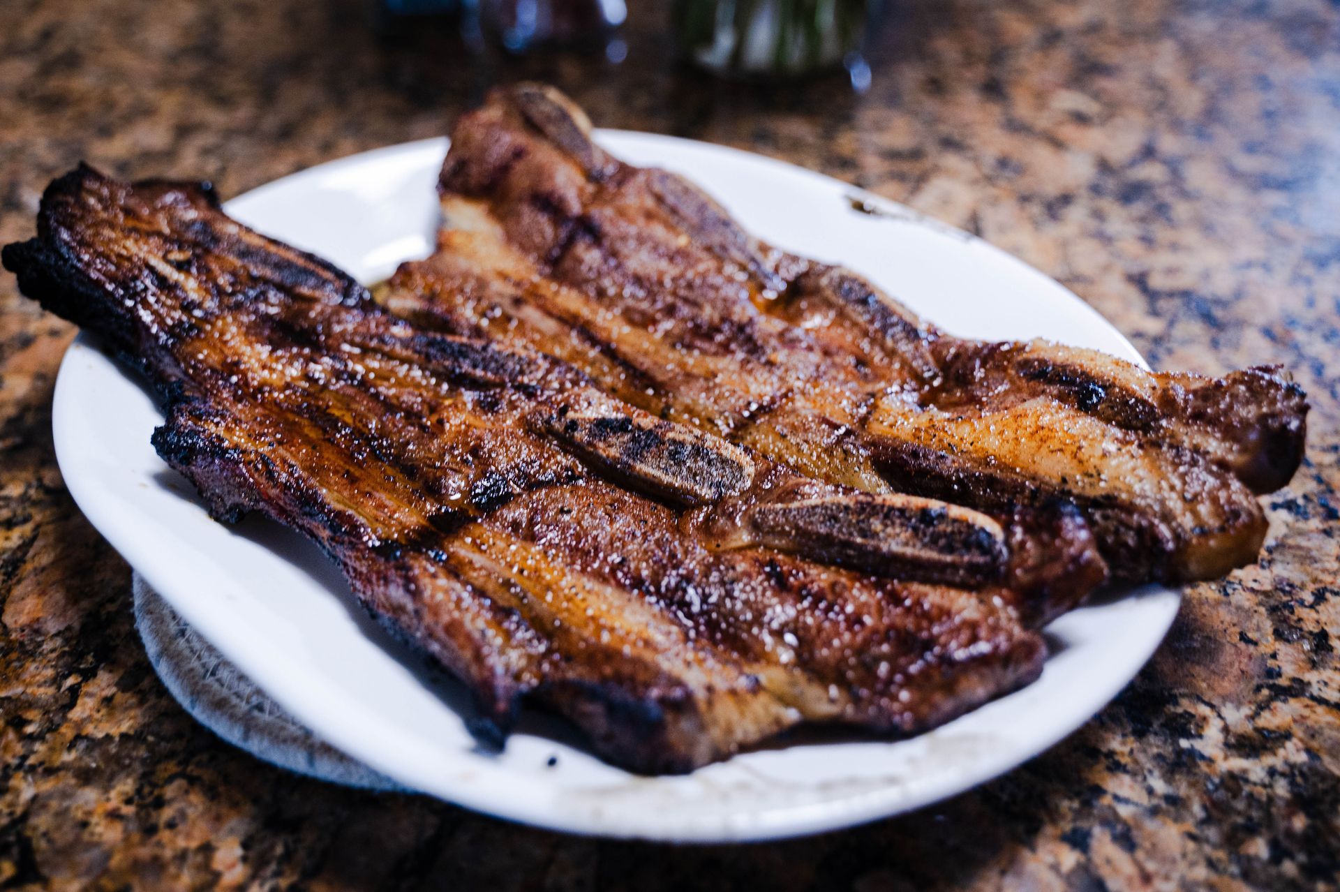 Cross-cut short ribs on a white plate after being grilled