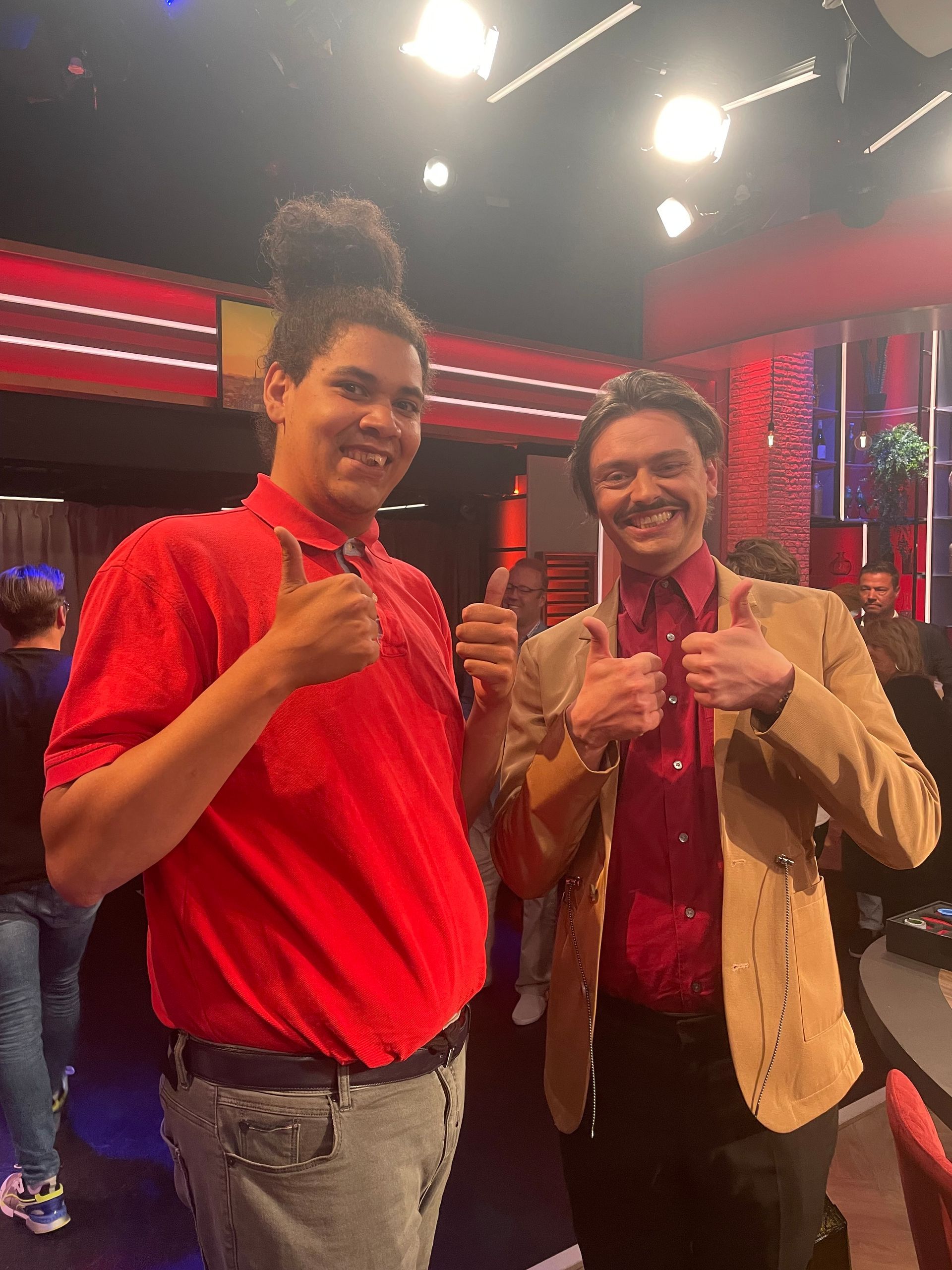 Twee mannen staan ​​naast elkaar en steken hun duim omhoog.