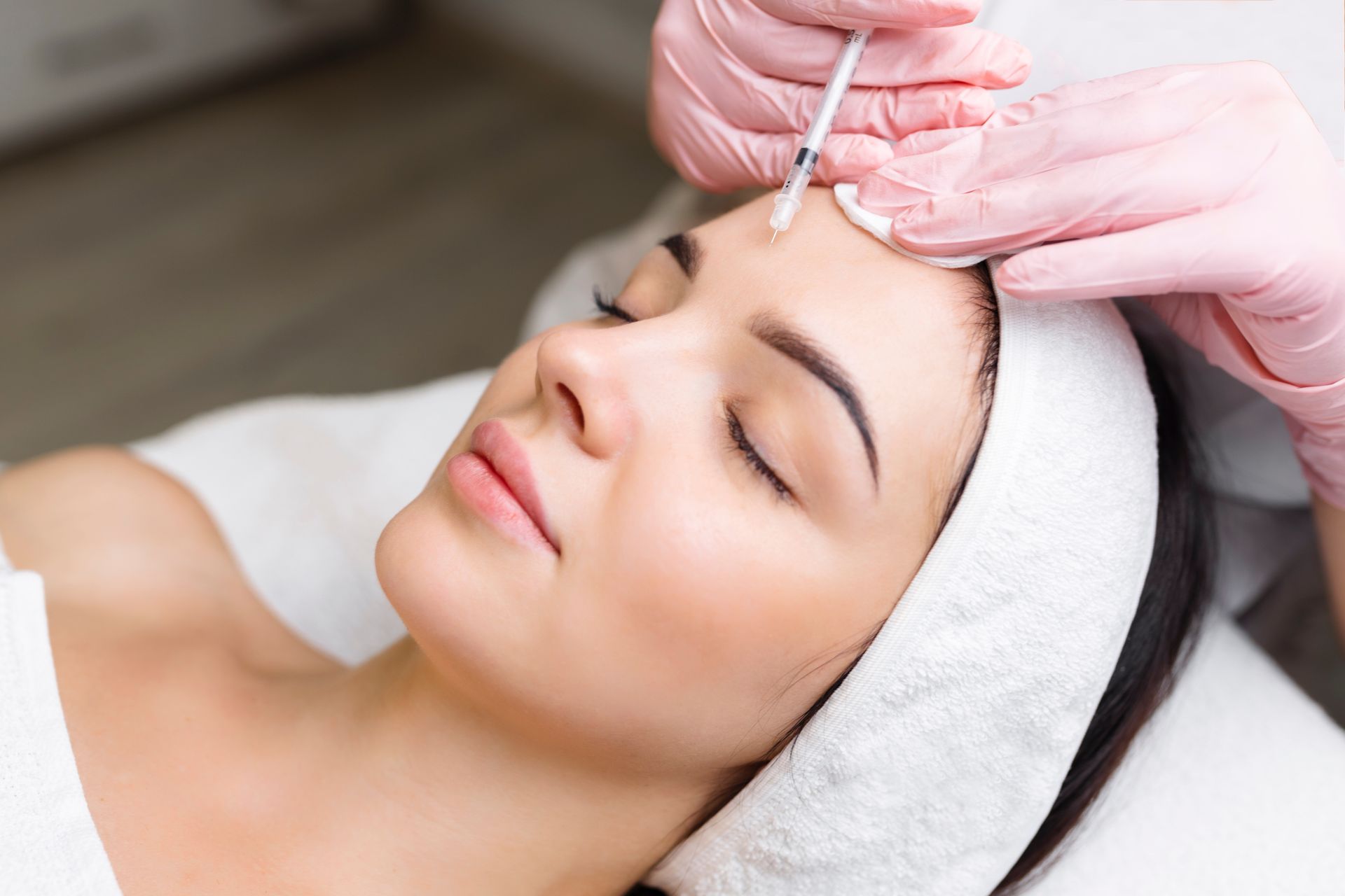 A woman is getting Botox on her forehead