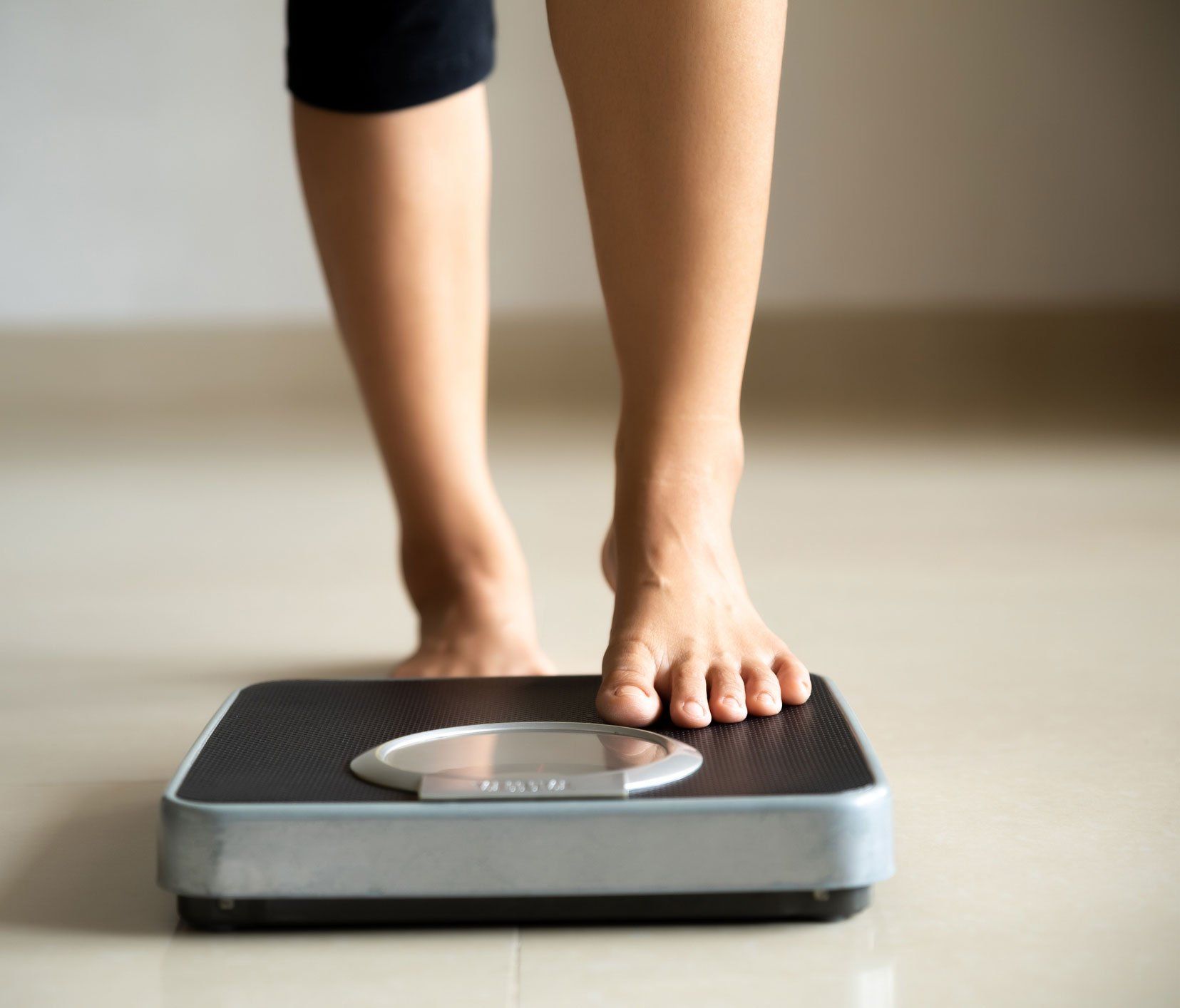 Woman Stepping On A Weighing Scale — Jacksonville, FL — Ageless Rejuvenation Center