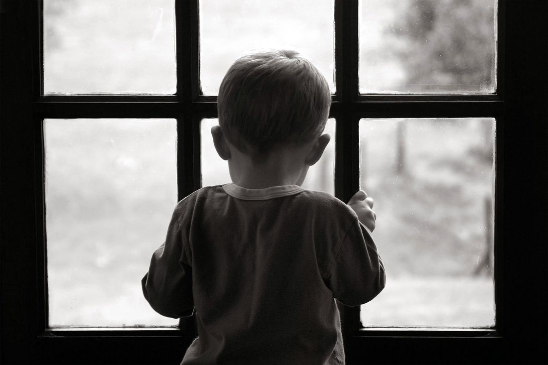 bambino dietro una finestra