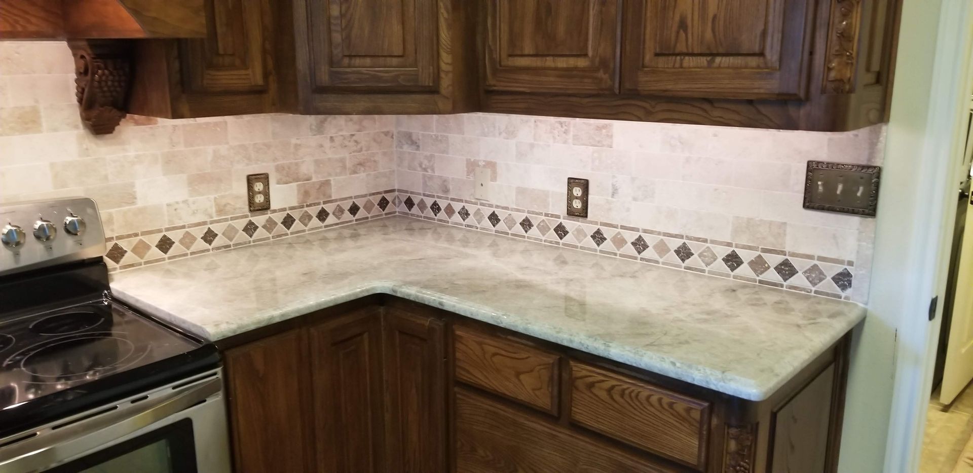 A kitchen with a stove , sink , and cabinets.