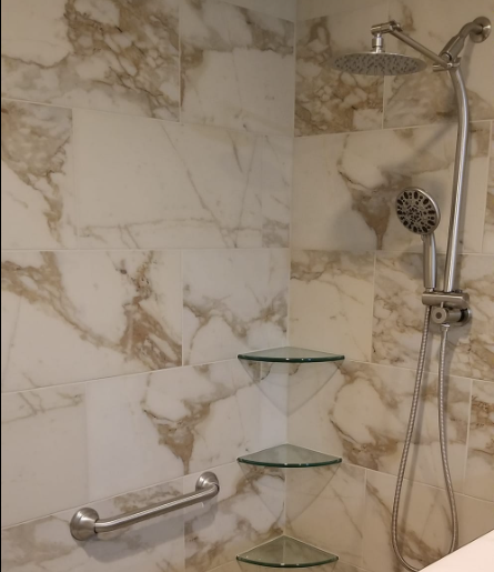 A bathroom with marble tiles and a shower head