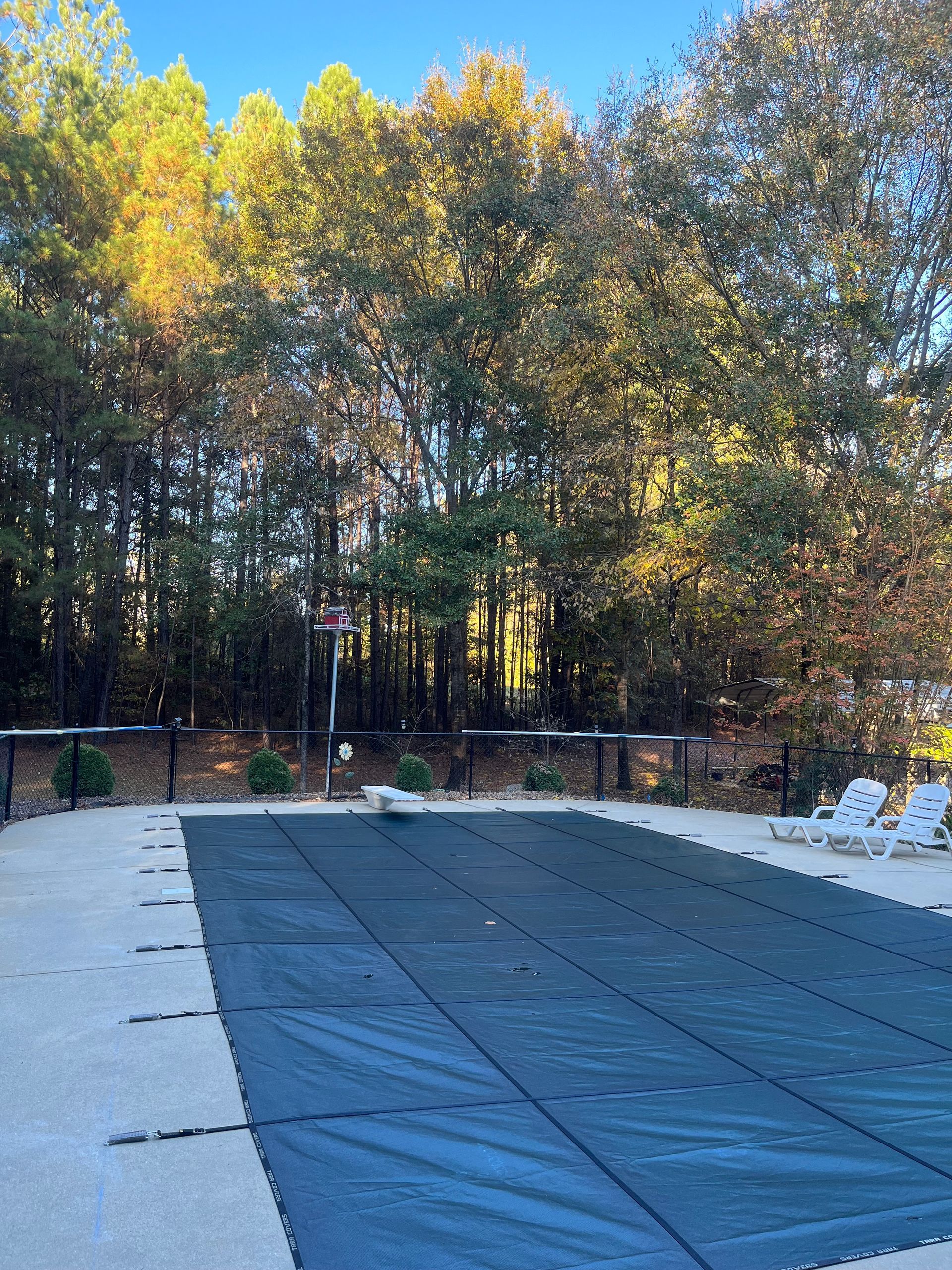A large swimming pool with a basketball hoop in the background.