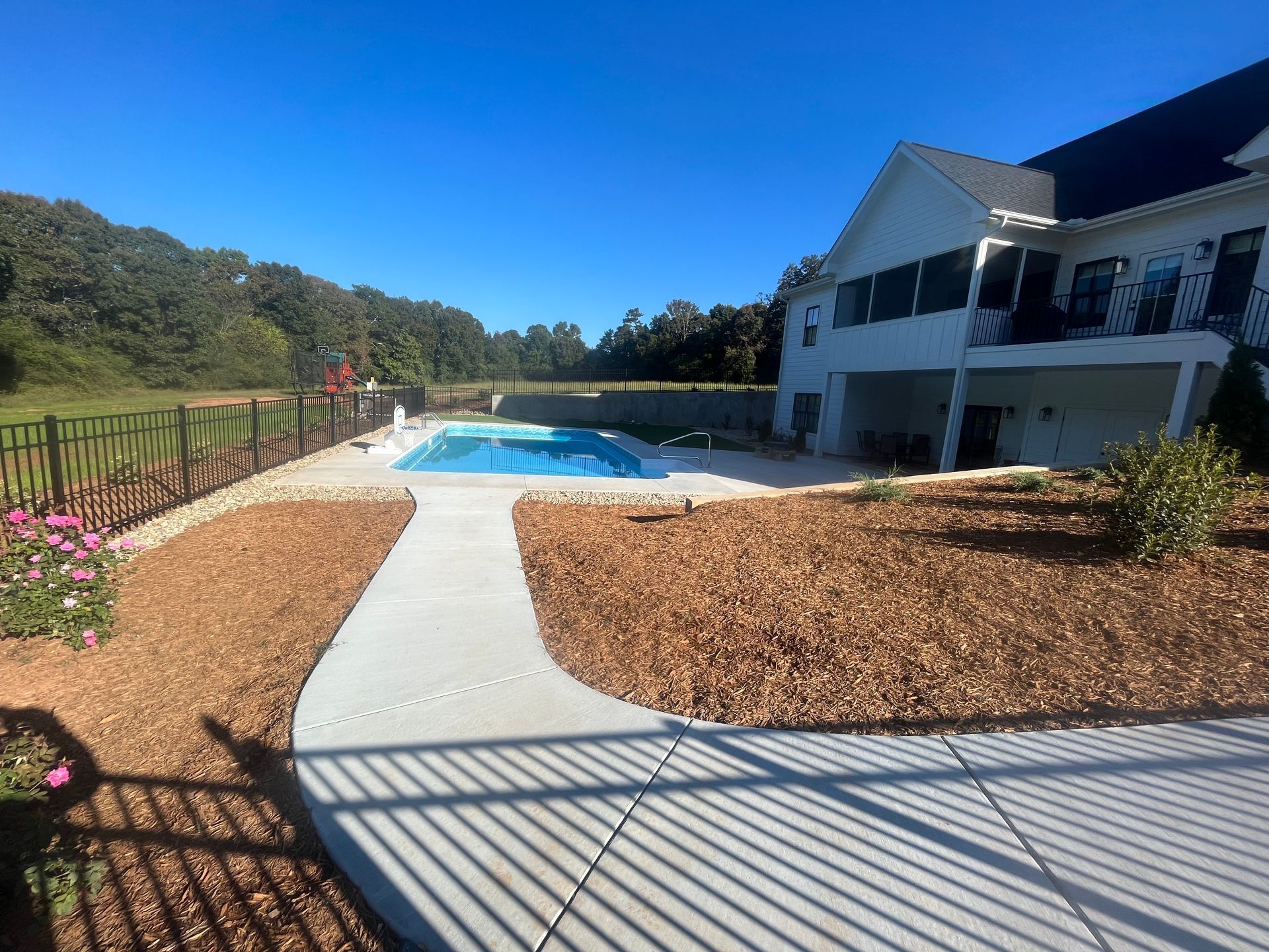 A large white house with a swimming pool in the backyard.