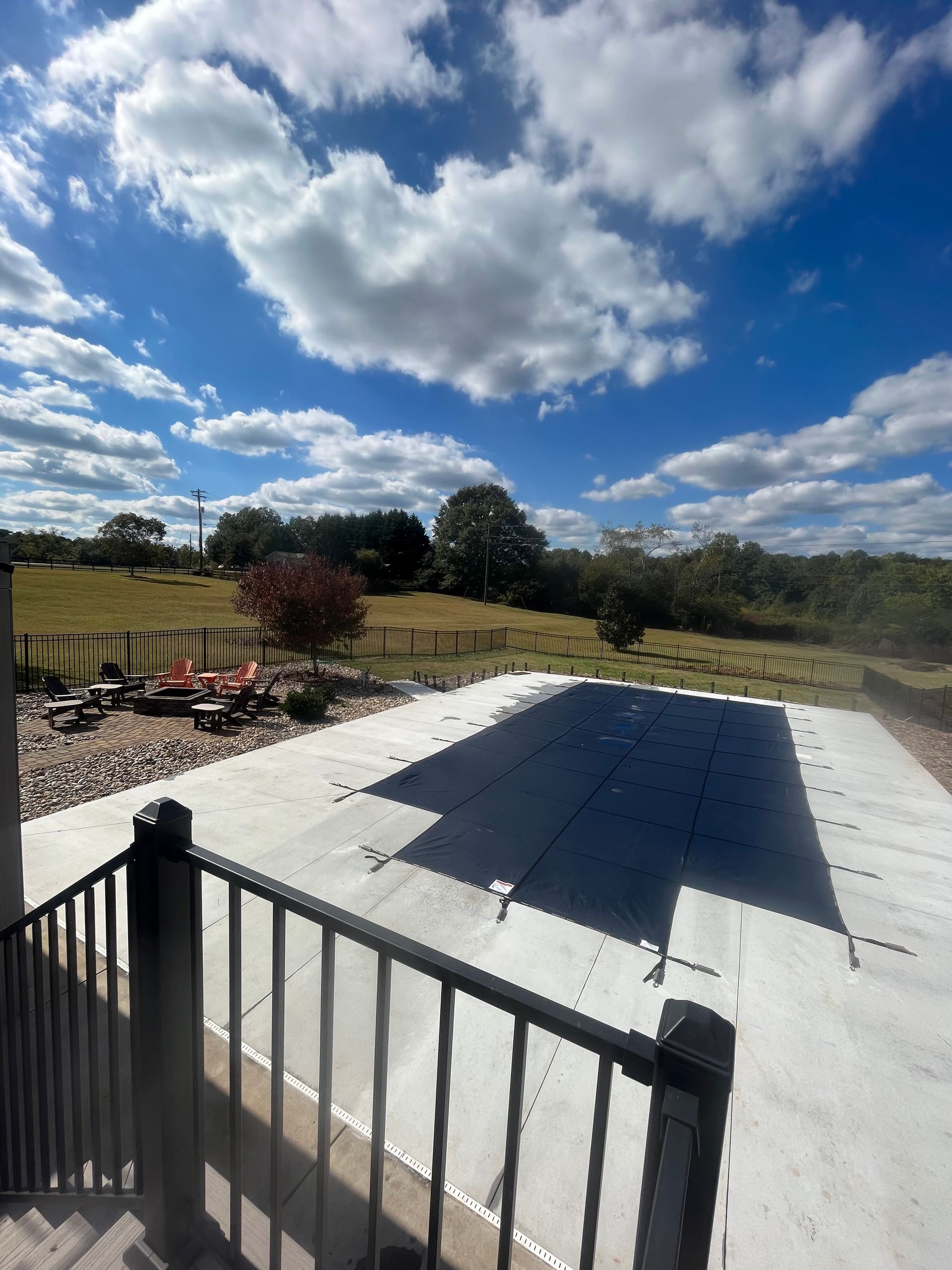 A large swimming pool with a black cover on it