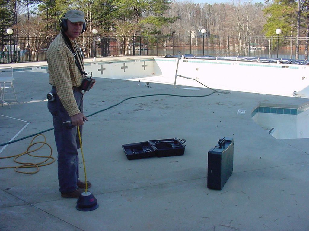 A man is standing in front of a swimming pool