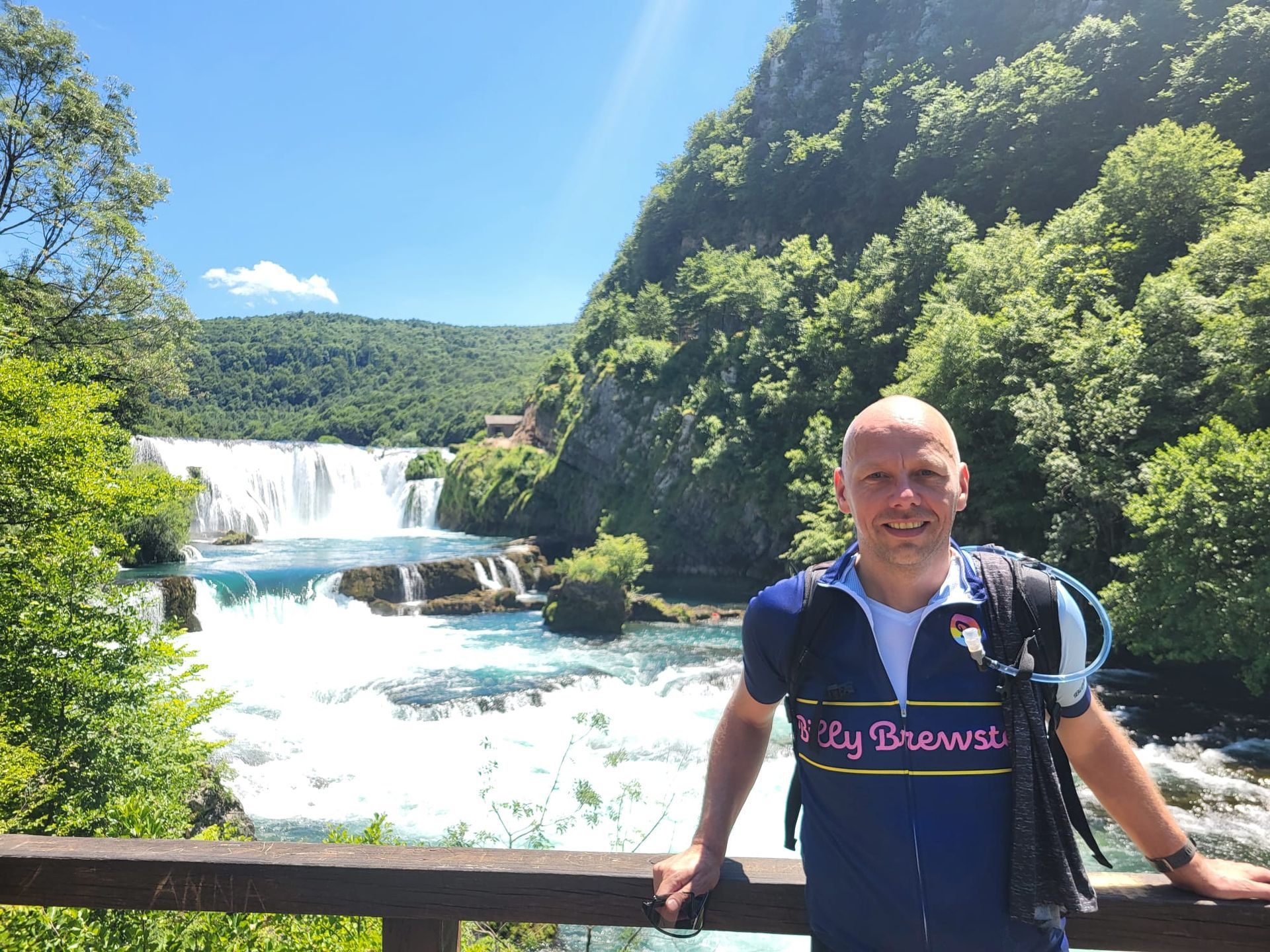 Mountainbiker posiert vor einem spektakulären Wasserfall an der Una