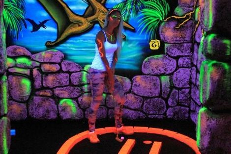 A woman is playing glow in the dark golf