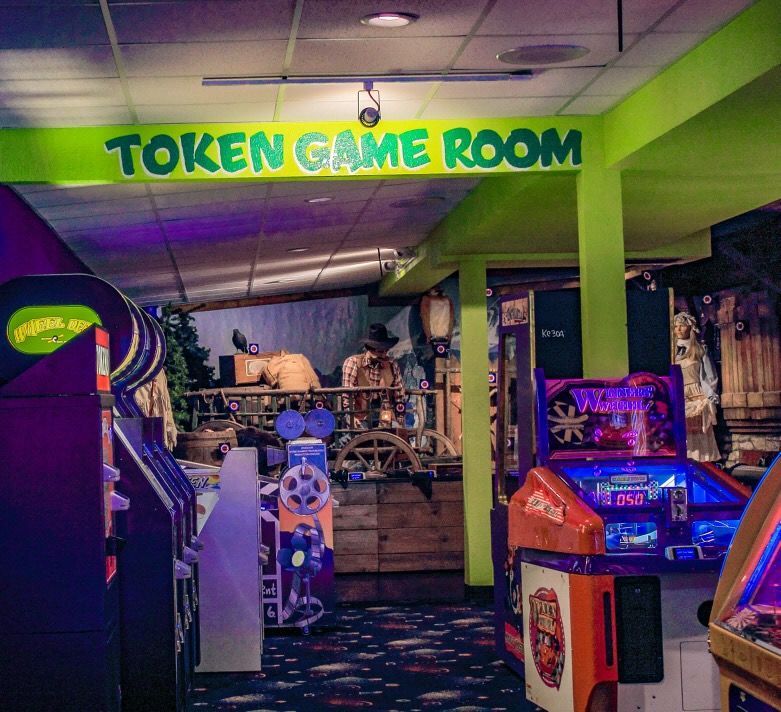 An arcade with a sign that says token game room