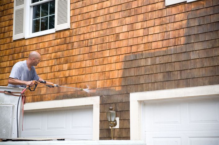 Man Is Cleaning The Side Of A House — Parkesburg, PA — Keystone Superior Cleaning 