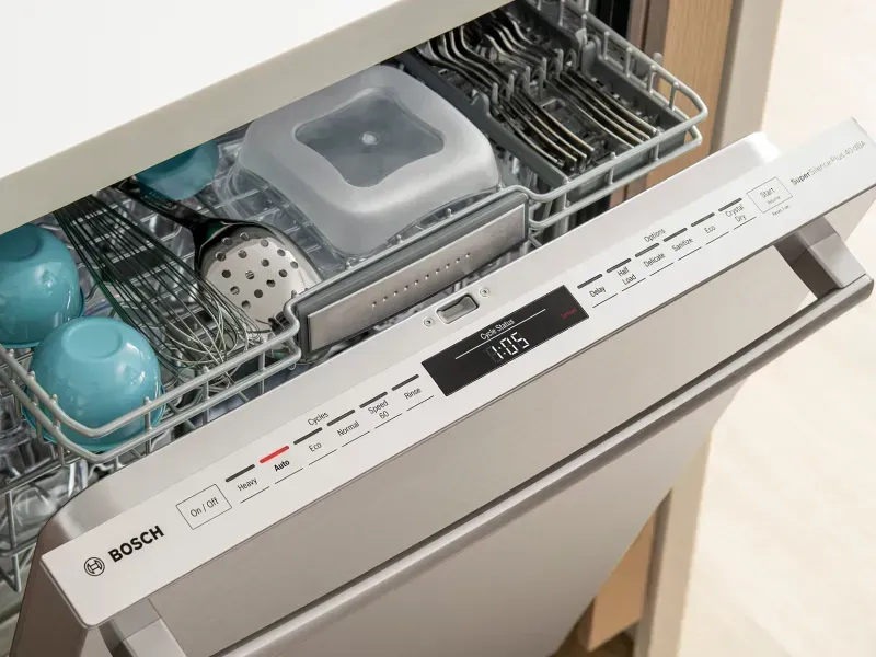 Technician repairing Bosch dishwasher with E24 error code in a modern kitchen