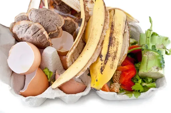 Un montón de desechos de comida que incluyen cáscaras de plátano, huevos y verduras.