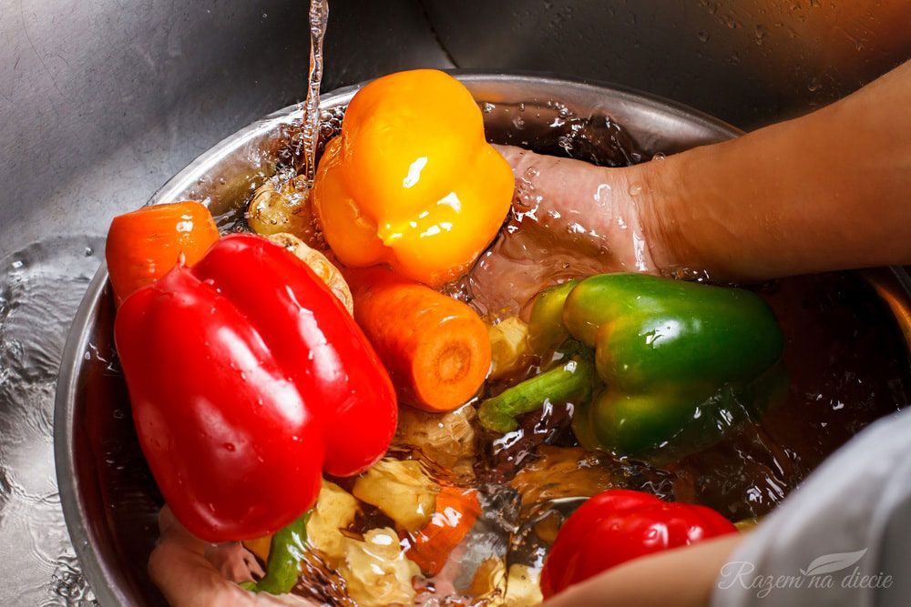 Una persona está lavando verduras en un fregadero.