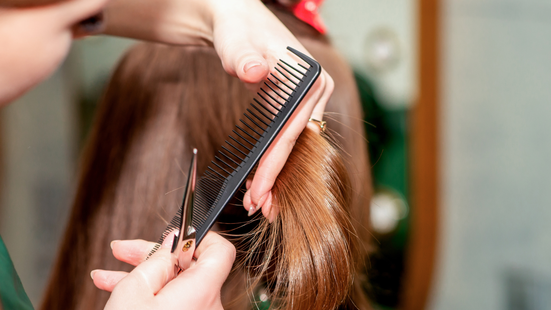 A woman is getting her hair cut by a hairdresser.