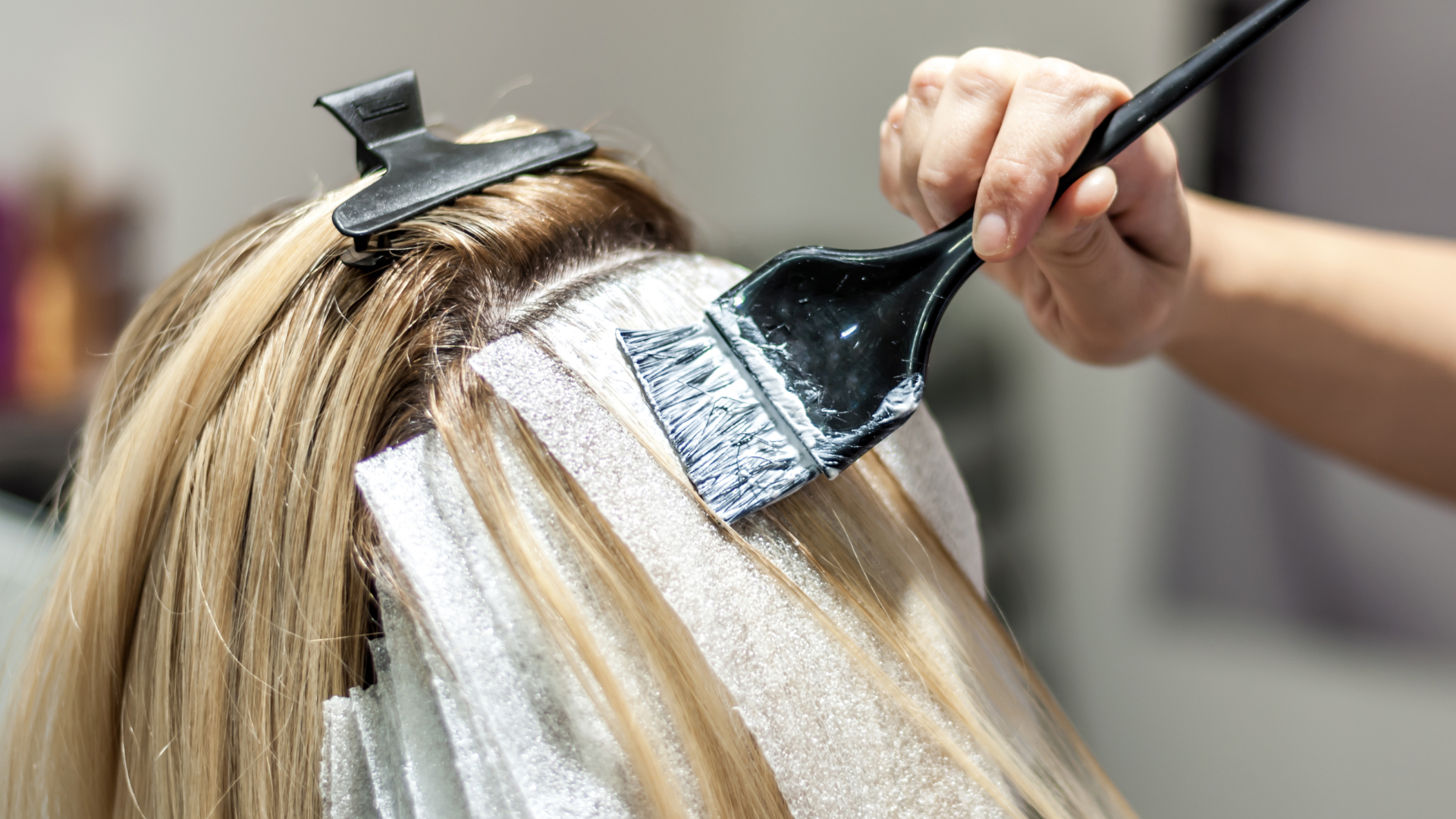 A woman is getting her hair dyed in a salon.