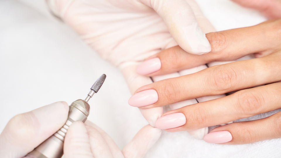 A woman is getting her nails done at a nail salon.