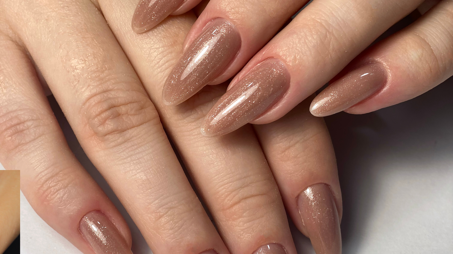 A close up of a woman 's nails with brown nail polish.