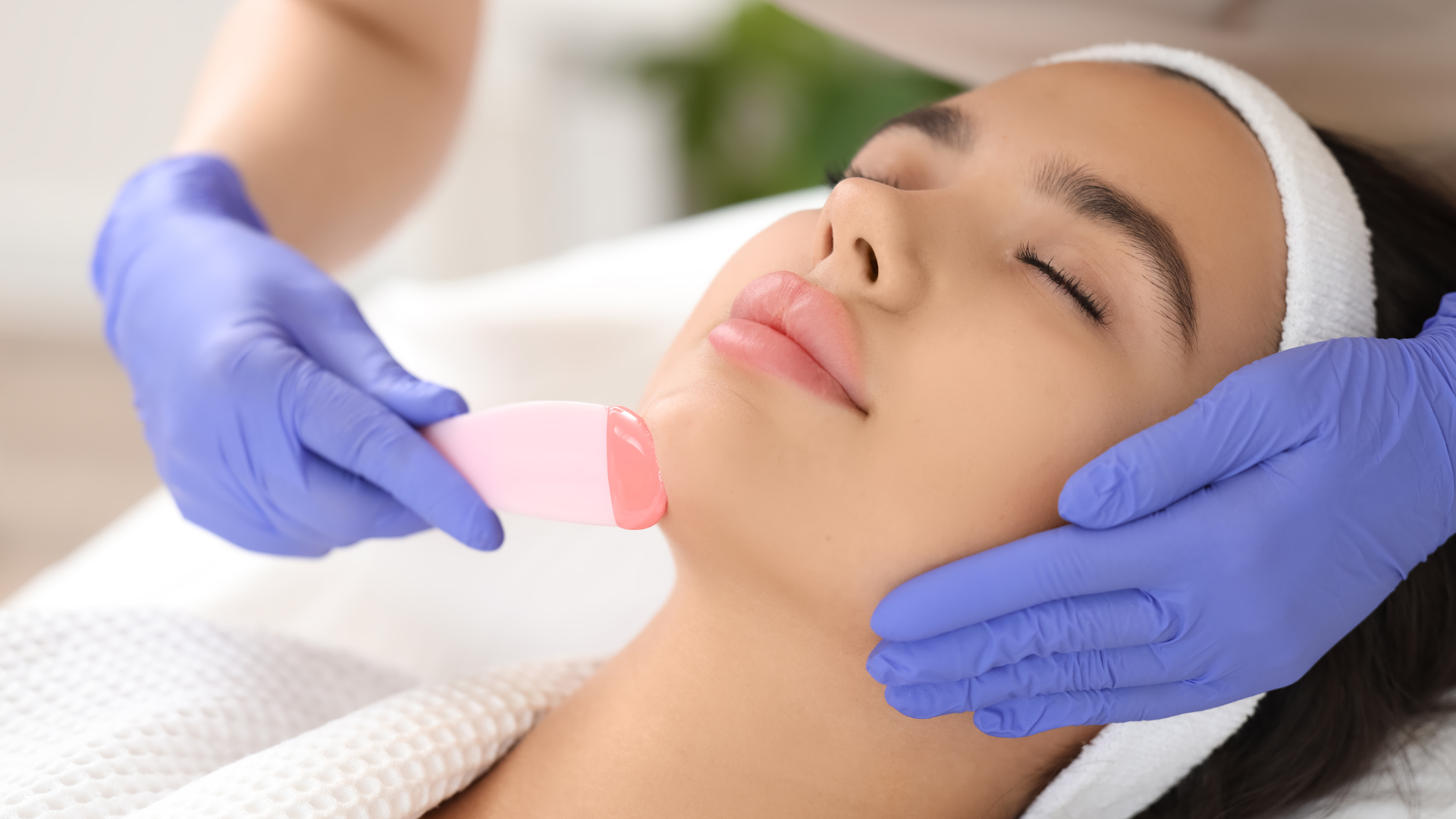 A woman is getting a facial treatment at a beauty salon.