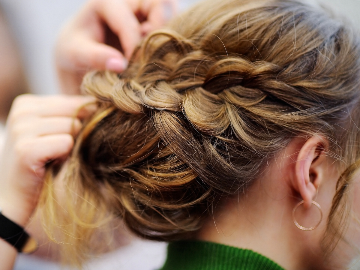 A woman is getting her hair done by a hairdresser.