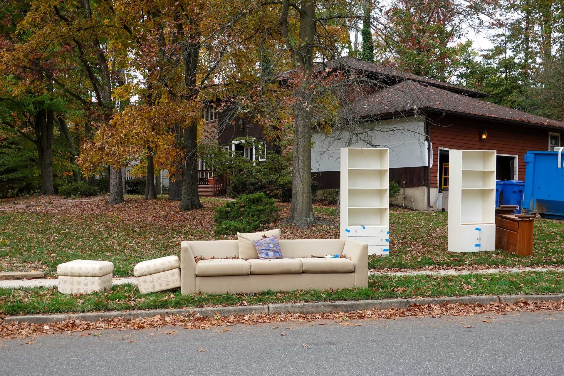 Woman in straw hat smiles, holding wine glass near a lake.