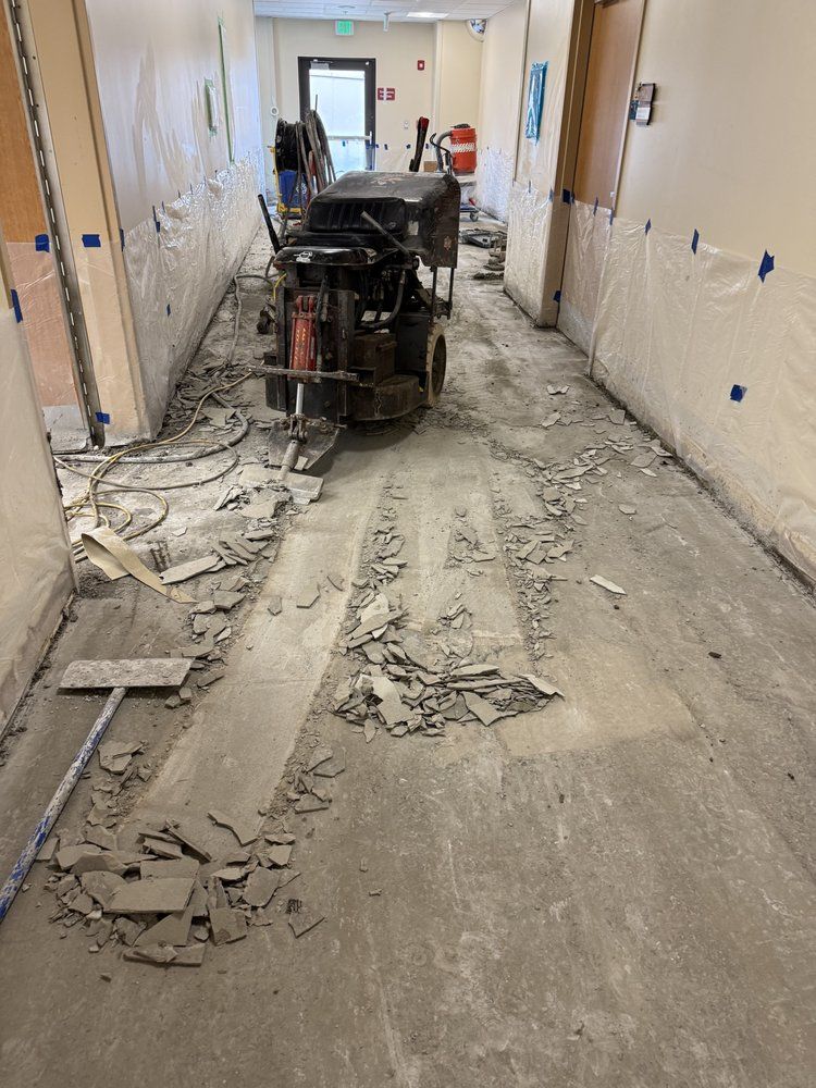 Construction debris scattered in a hallway with a wheeled machine in the center.