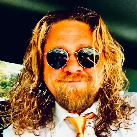 A man with long hair and a beard wearing sunglasses