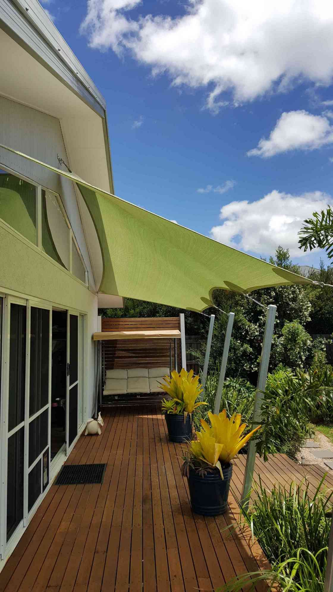 A Deck With Potted Plants and a Green Awning Over It — Style Shades Installation In Smithfield, NSW