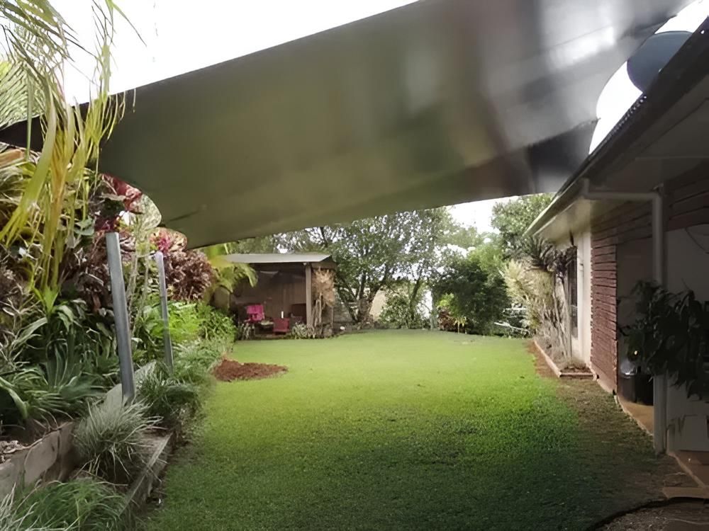 A Large Lawn With a Canopy Over It and a House in the Background — Style Shades Installation In Ravenshoe, QLD