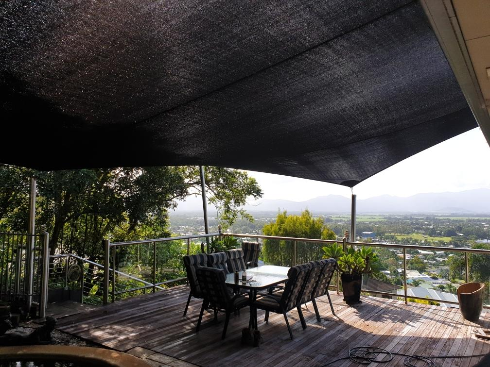 A Deck With a Table and Chairs Under a Black Canopy — Style Shades Installation In Cairns, QLD