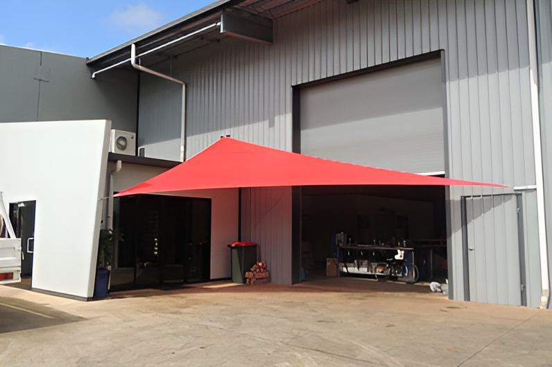 A Red Umbrella Is Sitting Outside Of A Building — Style Shades Installation In Edmonton, QLD