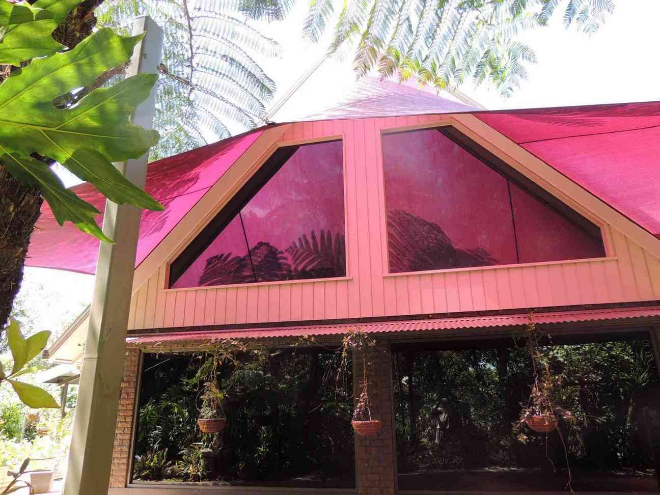 A Pink Umbrella Is Hanging From The Roof Of A Building — Style Shades Installation In Mareeba, QLD