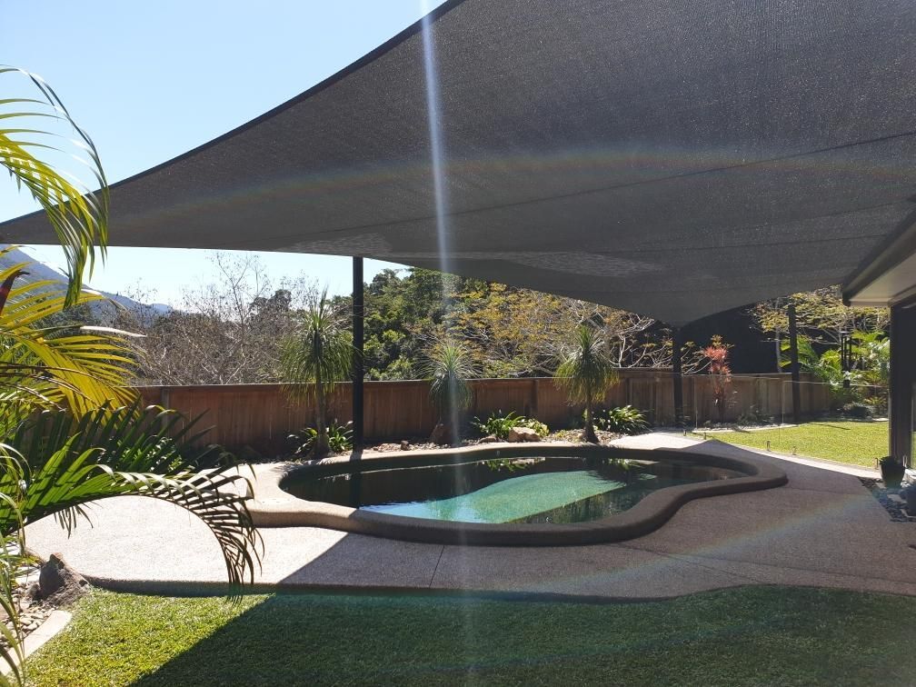 A Swimming Pool With A Shade Sail Over It — Style Shades Installation In Edmonton, QLD