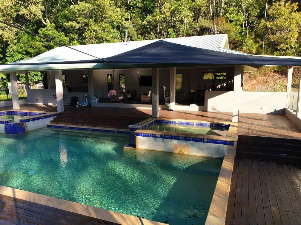 A Large House With A Swimming Pool In Front Of It — Style Shades Installation In Edmonton, QLD