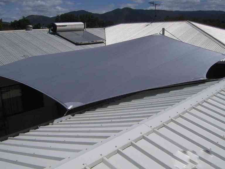 A White Roof With a Large Gray Tarp on Top of It — Style Shades Installation In Smithfield, NSW