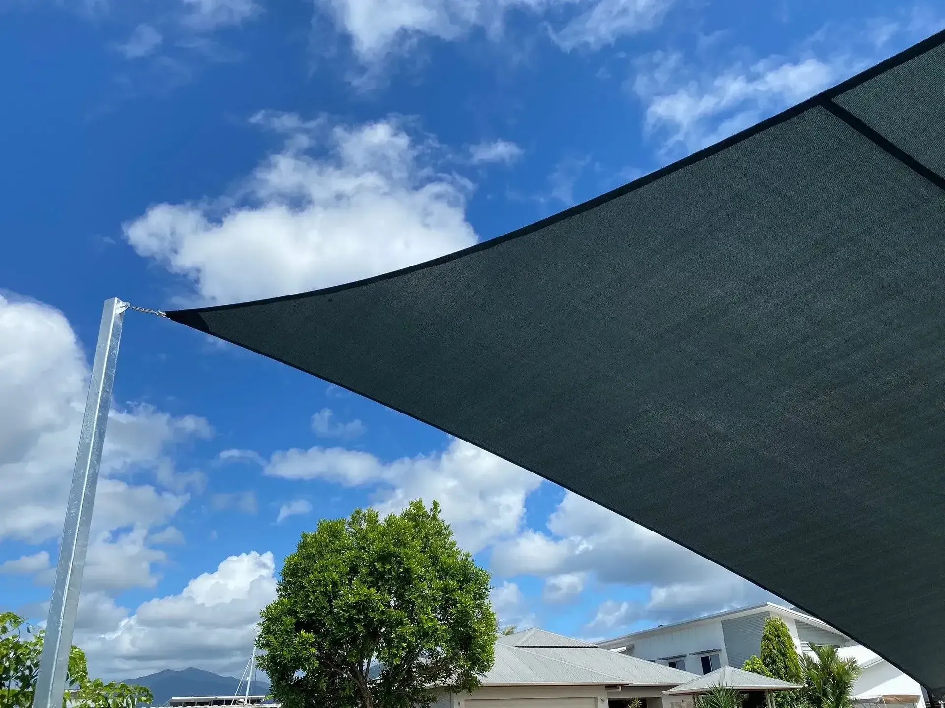 A Large Umbrella is Sitting in Front of a House on a Sunny Day — Style Shades Installation In Atherton Tablelands, QLD