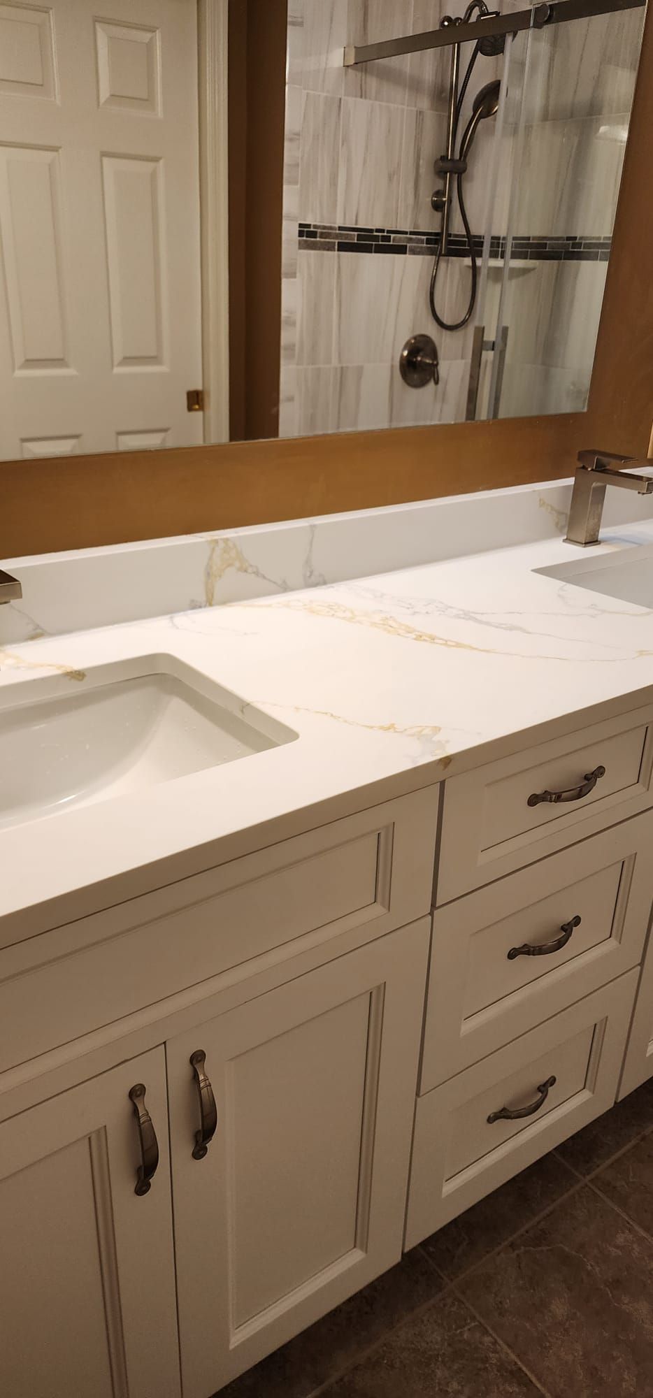 A bathroom with two sinks and a large mirror.