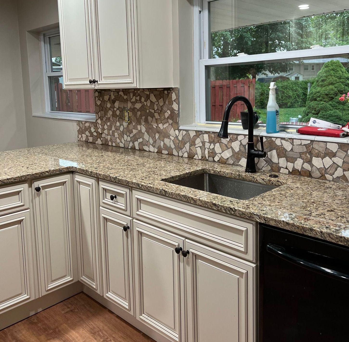 A kitchen with granite counter tops and white cabinets