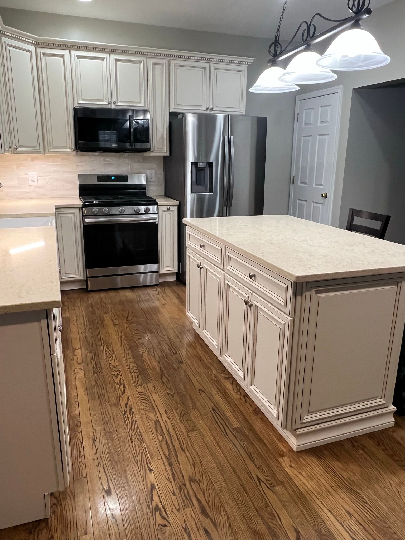A kitchen with stainless steel appliances and white cabinets