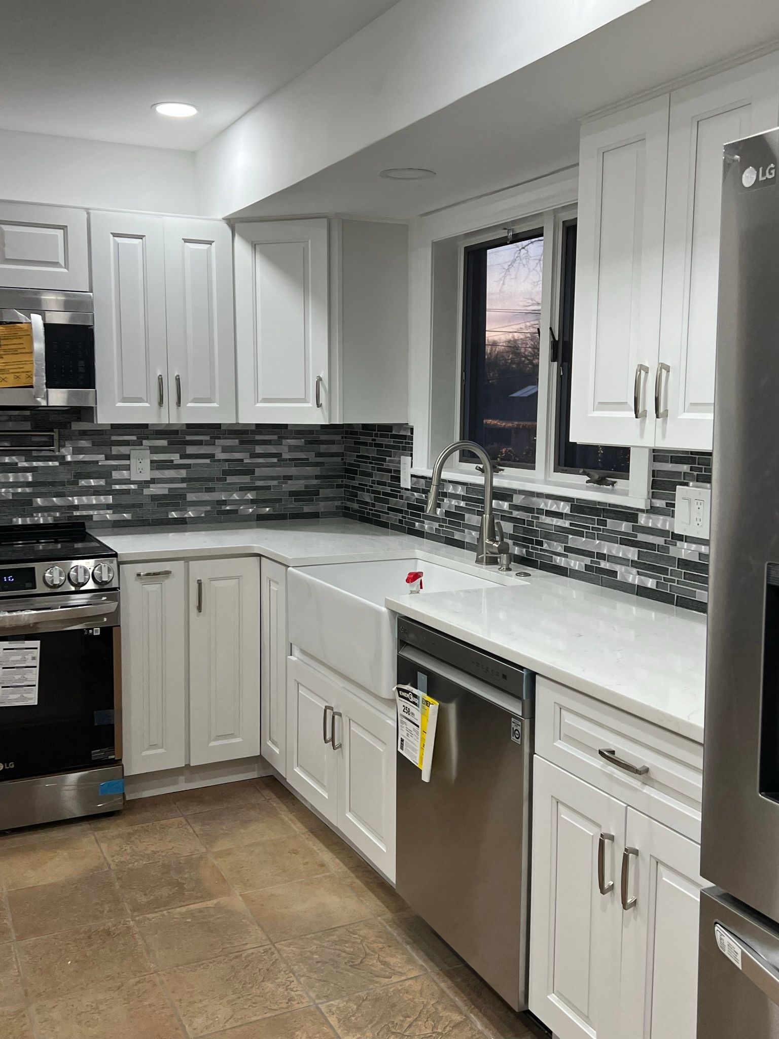 A kitchen with white cabinets and stainless steel appliances