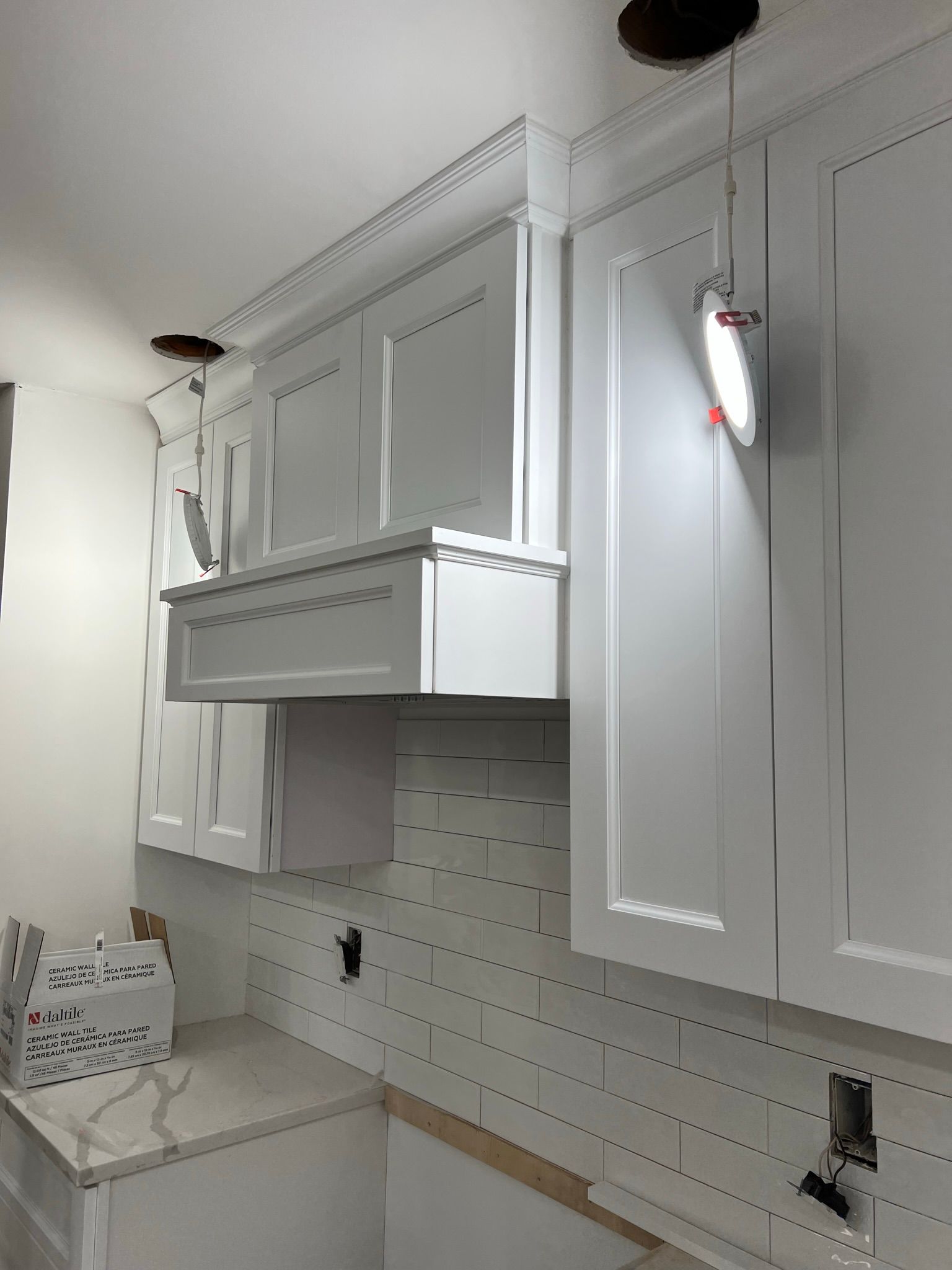 A kitchen with white cabinets and a light hanging from the ceiling.