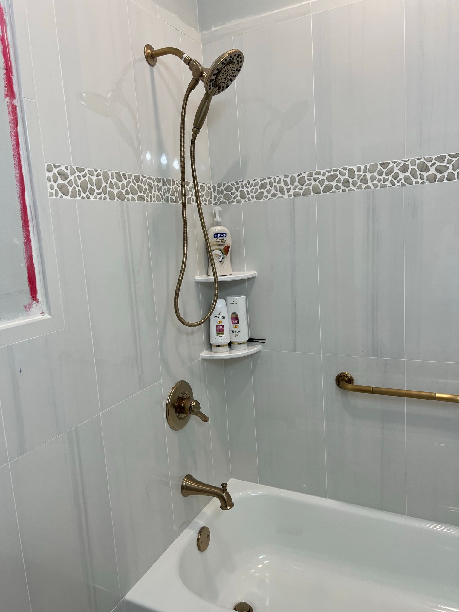 A bathroom with a bathtub and a shower head.